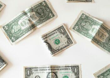 Dollars laid out on table (Unsplash | Emilio Takas)