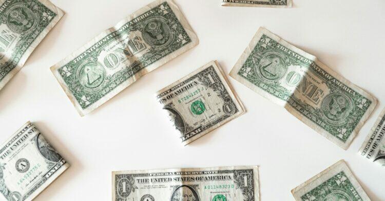 Dollars laid out on table (Unsplash | Emilio Takas)