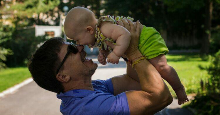 Father holding baby (Unsplash | Juliia Abramova)