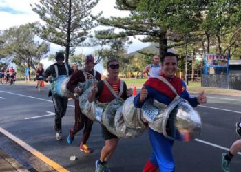 Friends running a marathon in a four-person costume
