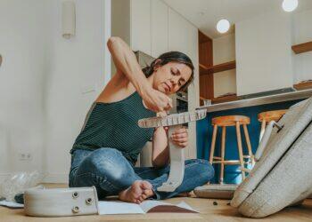 Woman sitting on the floor installing a DIY project (Unsplash | oppofindx5pro)