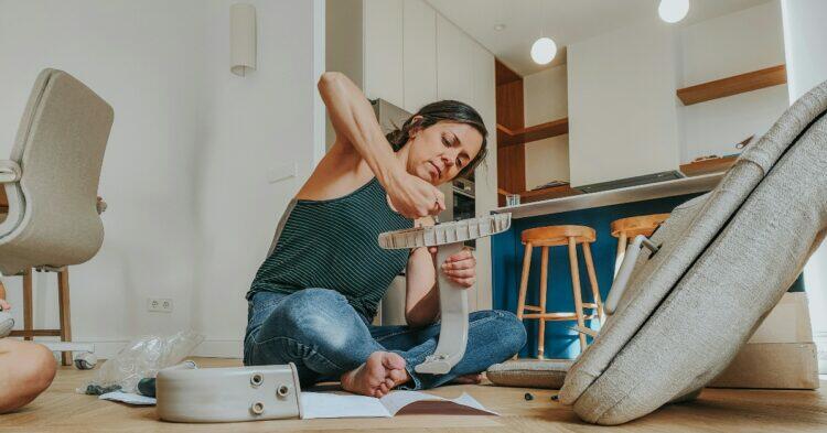 Woman sitting on the floor installing a DIY project (Unsplash | oppofindx5pro)