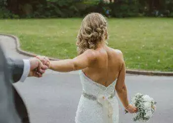 Bride and groom holding hands (Unsplash | Tom The Photographer)