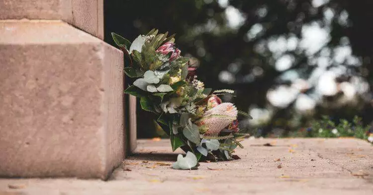 Flowers on grave (Unsplash | Caroline Attwood)