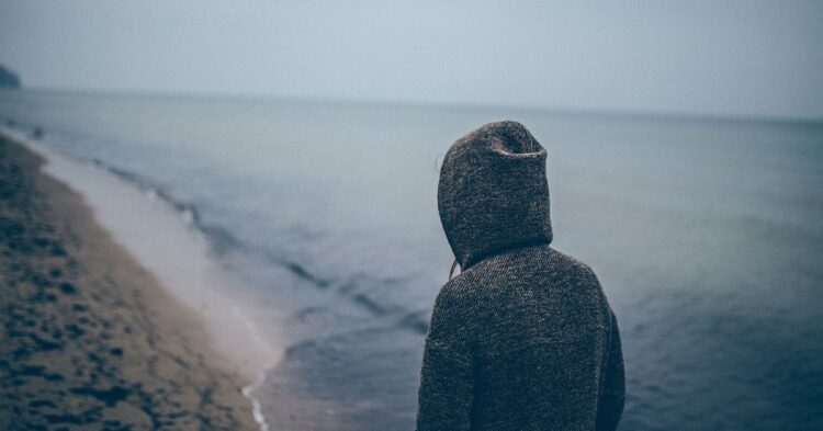 Person at the beach with their back to the camera (Unsplash | - -)