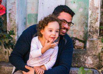 Father and daughter sitting at doorstep (Unsplash | Jonas Kakaroto)