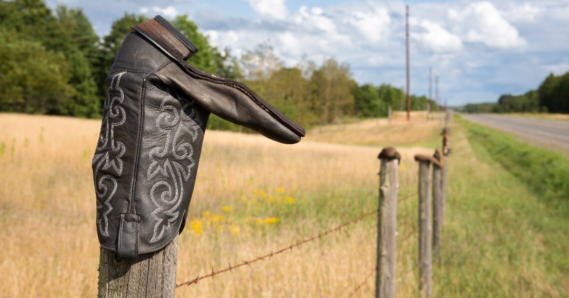 Cowboy boot upside down on a fence (Getty | James Pintar)