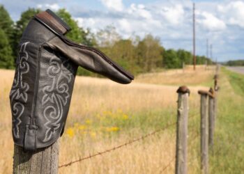 Cowboy boot upside down on a fence (Getty | James Pintar)