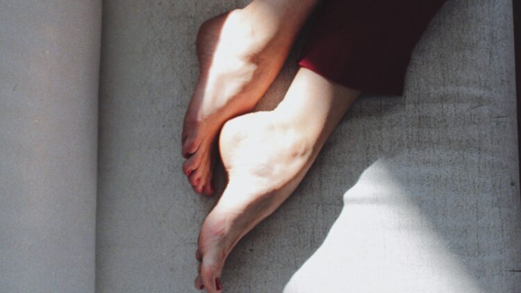 Image of feet on bed (Unsplash | Misha Gord)