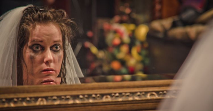 Bride with smudged makeup stares at herself in the mirror (Getty Images | meshaphoto)