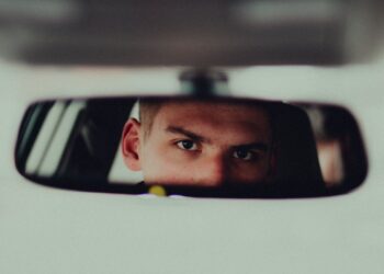 Man looking in car mirror