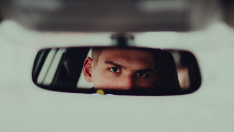 Man looking in car mirror