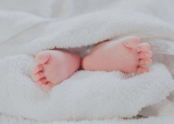 Baby feet under blanket (Unsplash | Fé Ngô)