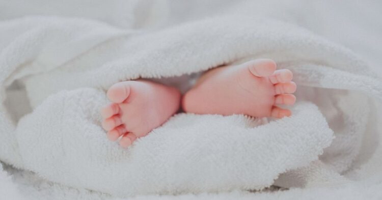 Baby feet under blanket (Unsplash | Fé Ngô)