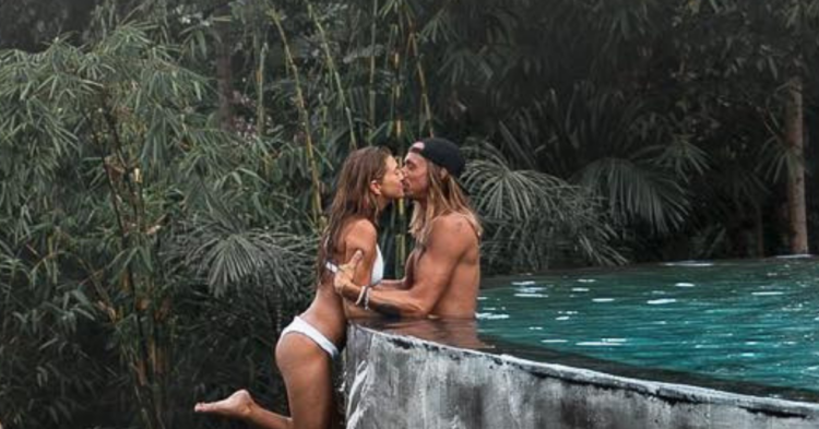 The controversial photo posted by @positravelty on Instagram where Kelly seems to be dangling off the cliff of a roof pool.
