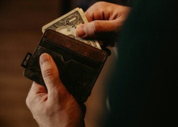 person getting 1 U.S. dollar banknote in wallet