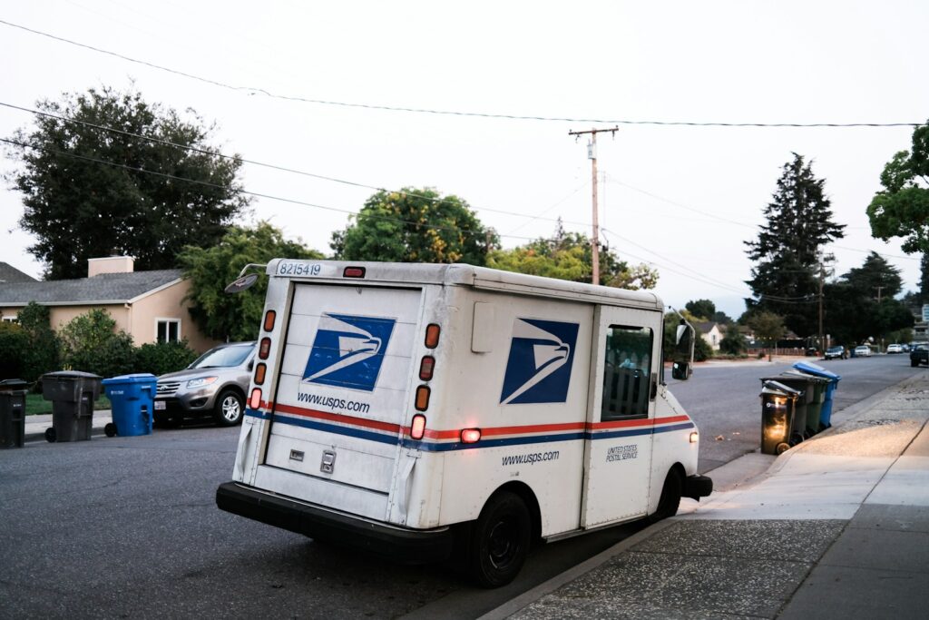white and blue delivery truck on road during daytime