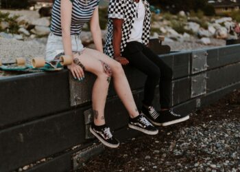 two person sits on fence