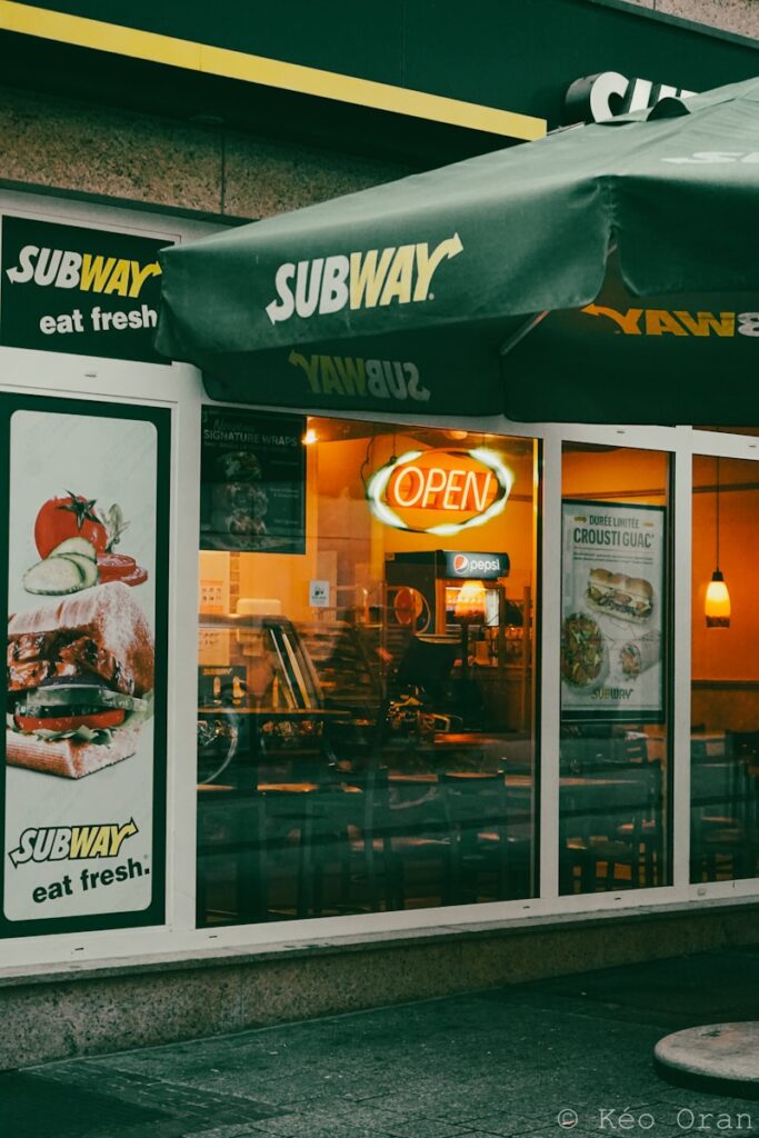 a subway restaurant with a green awning