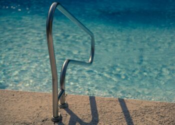 selective focus photography of stainless steel pool rail