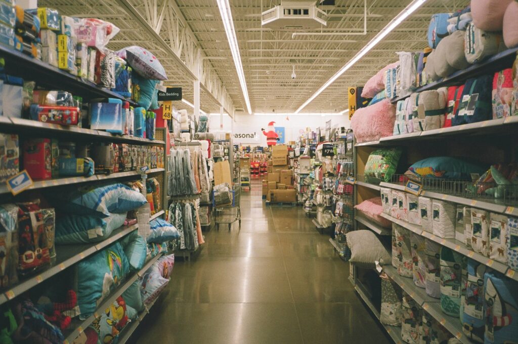 assorted items on white wooden shelf inside of a Walmart