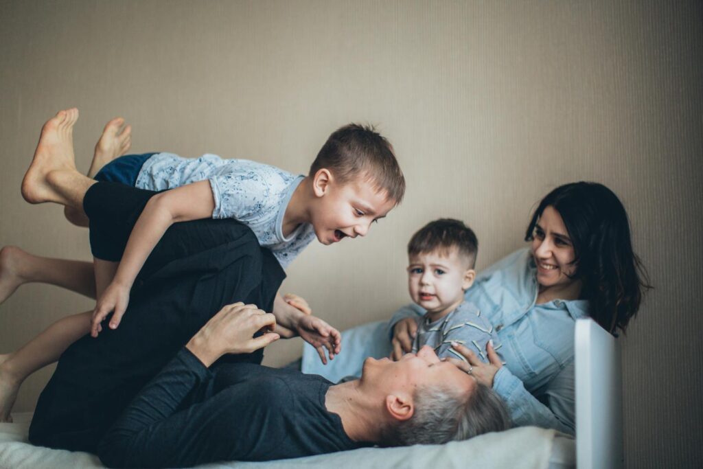 Parents playing with two young children in their home