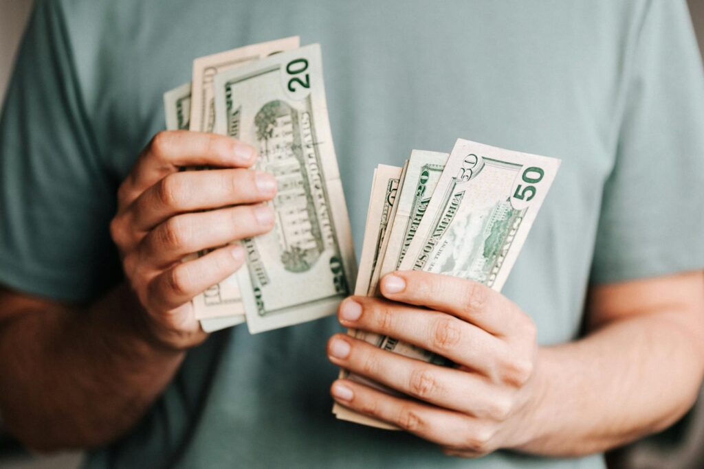 Cropped picture of man counting dollar banknotes