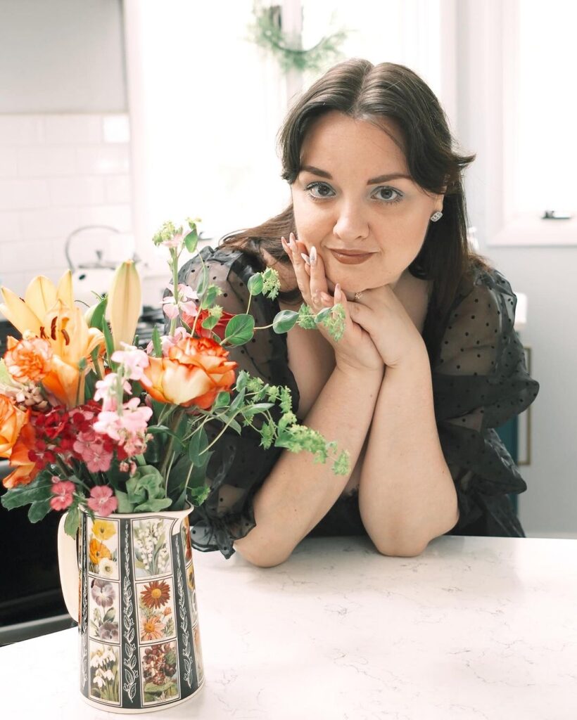 Lynzi Judish in her kitchen with a bouquet of flowers in a vase