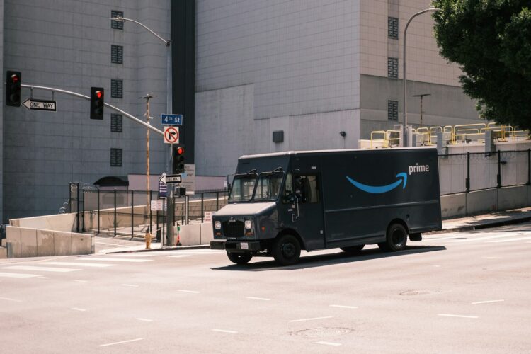 blue and white Amazon van parked near white building during daytime