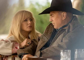 a still from “yellowstone” of a woman kneeling next to a man