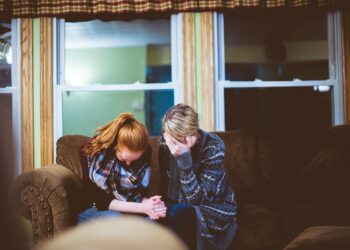 man and woman sitting on sofa in a room