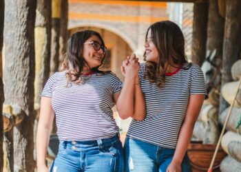 two smiling women while holding their hands at daytime