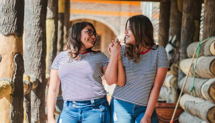 two smiling women while holding their hands at daytime