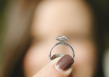 shallow focus photography of woman holding a diamond ring