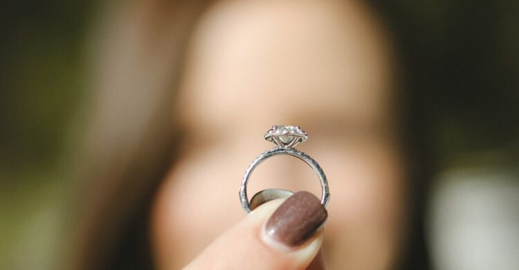 shallow focus photography of woman holding a diamond ring