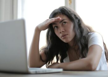 young annoyed female sitting in front of laptop
