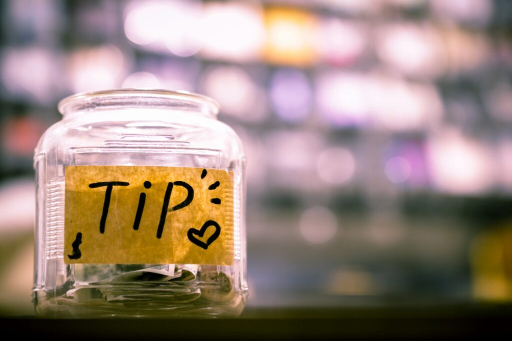 clear glass tip jar sitting on a counter