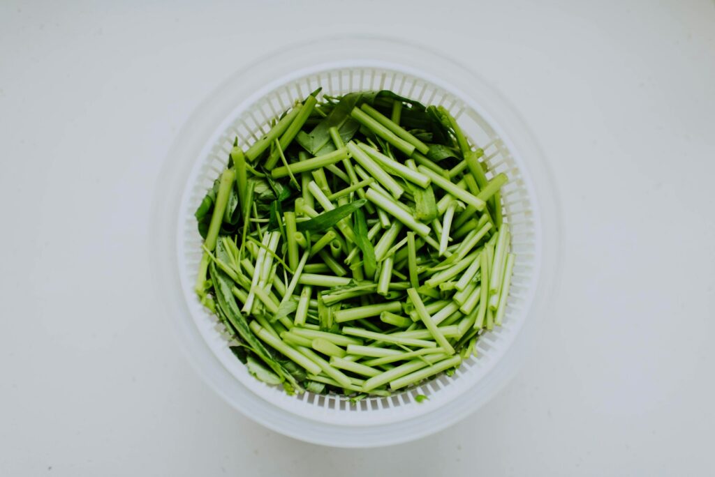 Green onions cut up in a white bowl.