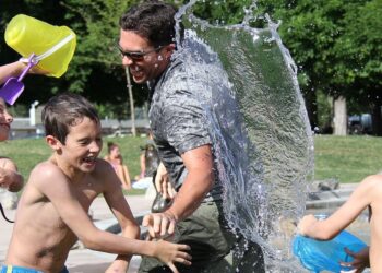children and man in a water fight