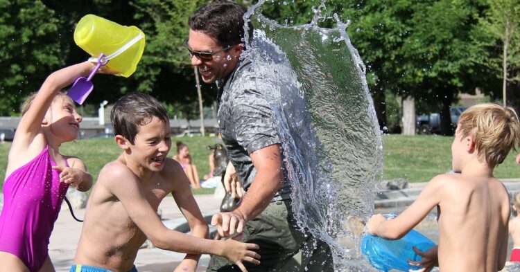 children and man in a water fight