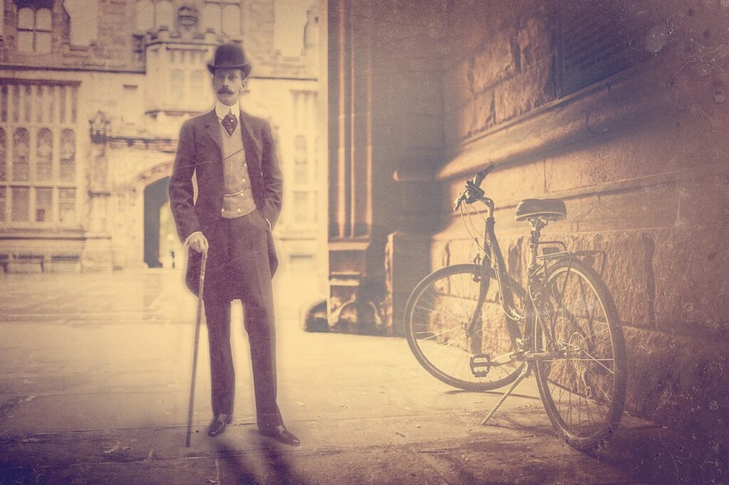 A man in a top hat with a cane next to a bicycle. Old fashioned style picture