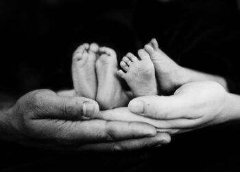grayscale photo of person holding baby