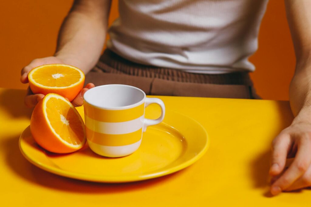 Person Holding A Slice Of Orange Fruit