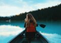 blonde haired woman riding on a canoe boat