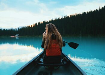 blonde haired woman riding on a canoe boat