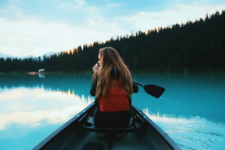 blonde haired woman riding on a canoe boat