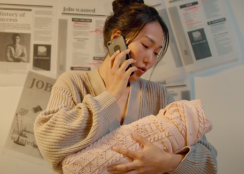 Woman cradling baby and talking on the phone