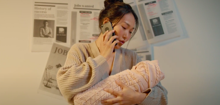 Woman cradling baby and talking on the phone