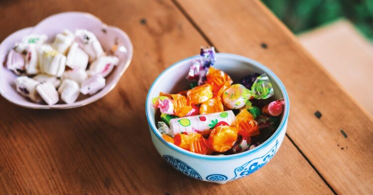 two bowls of colorful candy on a wooden table top