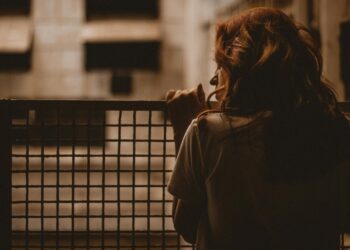 sad woman overlooking apartment complex